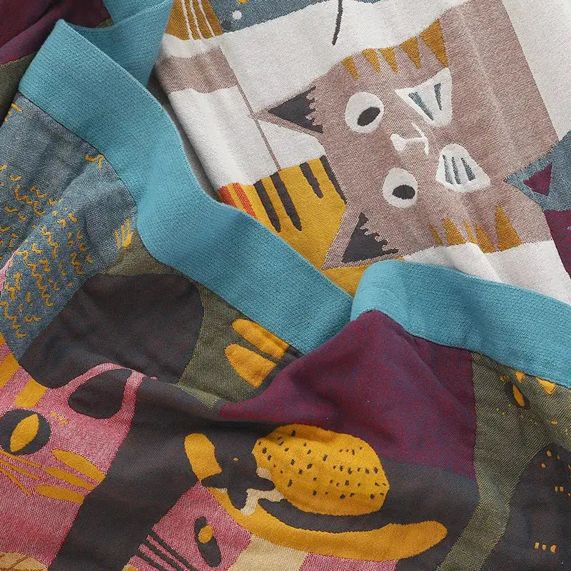 Multicolor boho printed cotton blanket featuring stylized cartoon cats in teal mustard maroon and gray geometric pattern