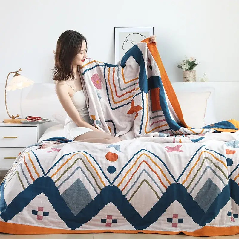 A cozy multicolor boho printed cotton blanket with vibrant blue orange and white geometric cat pattern for bedroom decorbites boho printed