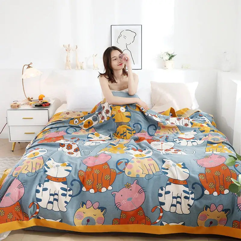 A cozy boho printed cotton blanket in blue with colorful cartoon cats and floral accents for bedroom decorbites decor