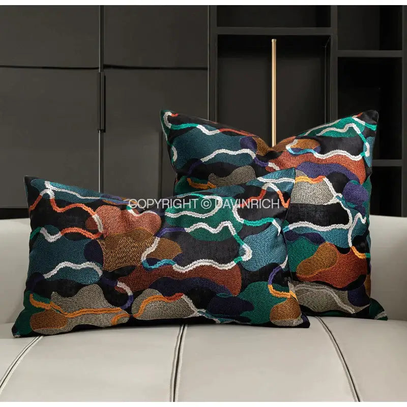 Two rectangular cushion covers with decorbites geometric embroidery abstract patterns in teal orange brown and white