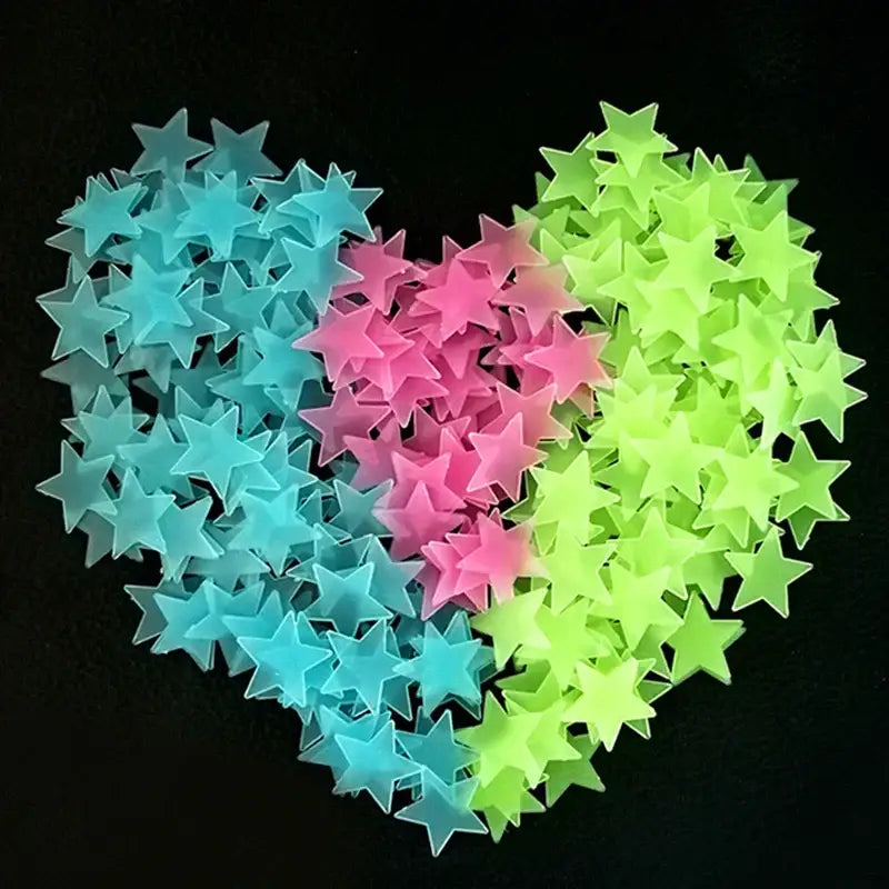A collection of translucent blue pink and neon green stars glow dark wall stickers arranged in a heart shape