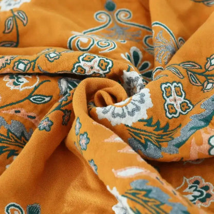 A soft orange cotton throw blanket with vibrant floral paisley decorbites gauze flowers pattern for bedroom decor