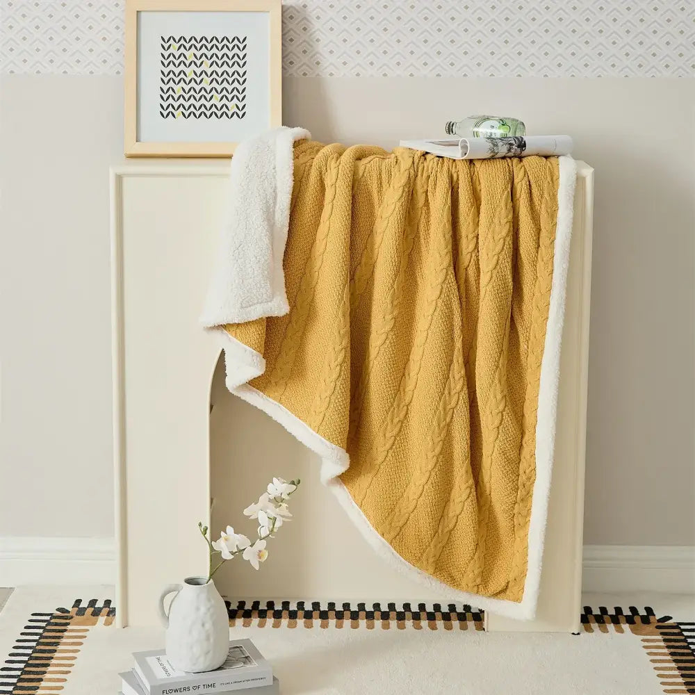 A cozy mustard yellow decorbites cable knit sherpa blanket with plush white lining perfect for bedroom throw use