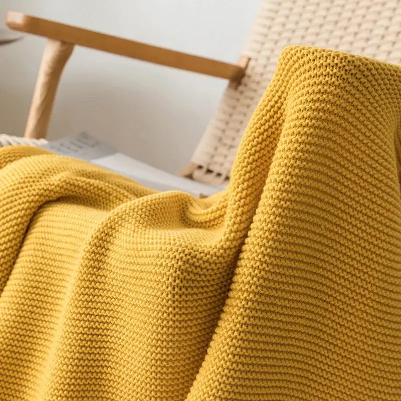 A cozy mustard yellow decorbites knit pompom tassel throw blanket with a textured ribbed pattern for bedroom decor