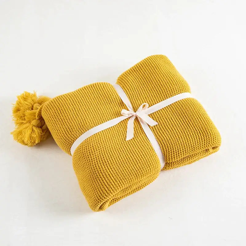 Cozy mustard yellow decorbites knit pompom throw blanket with fluffy pompom tassel and white ribbon tie for bedroom decor