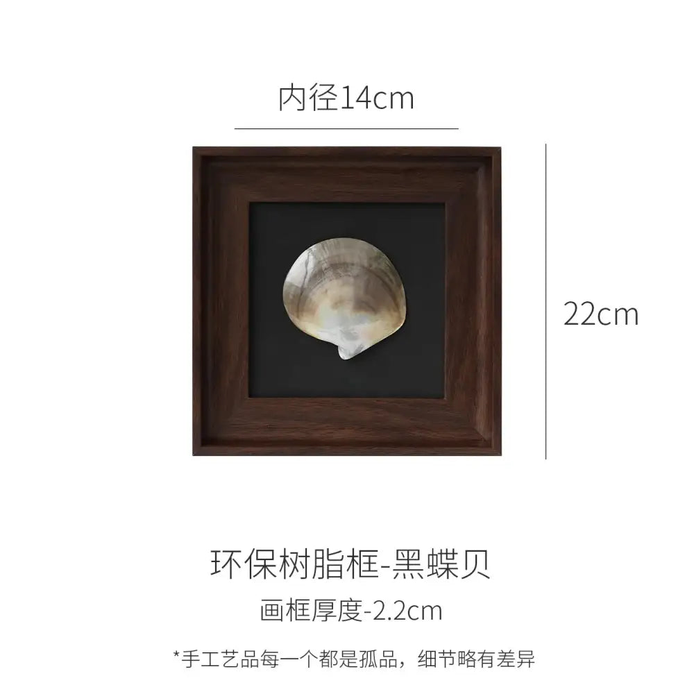 A dark brown wooden decorative painting frame with a natural black abalone shell on a matte black background