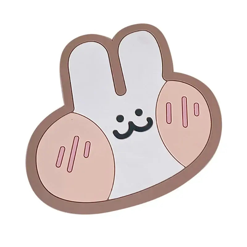 Cute white bunny-shaped phone stand with pink cheeks and brown outline next to natural lace bamboo woven coasters and storage basket set