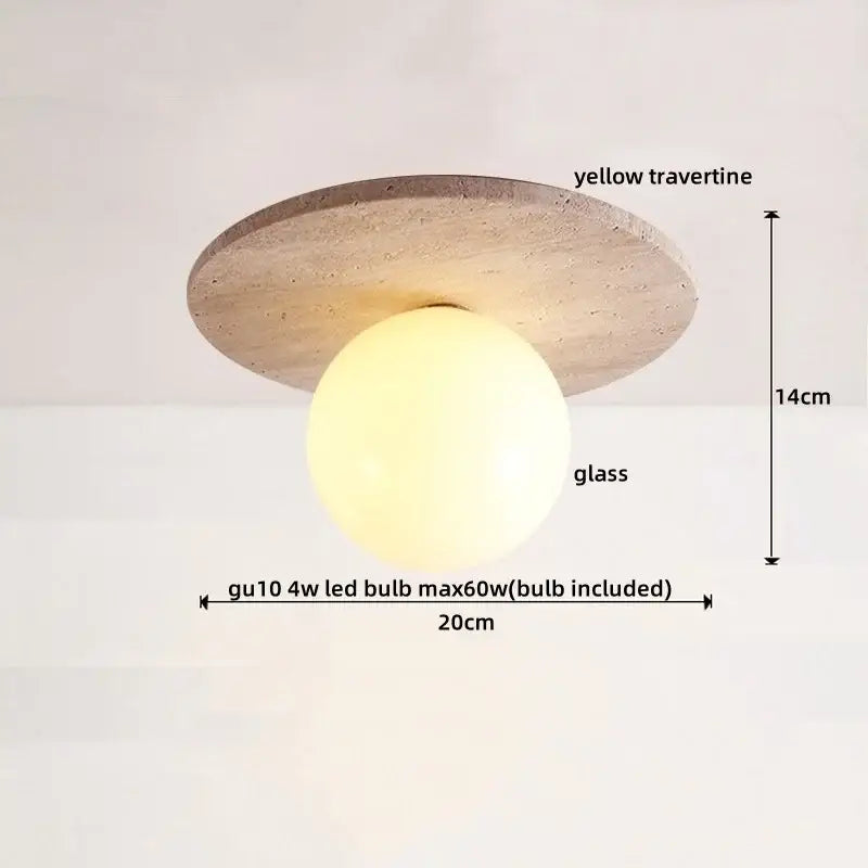 A modern ceiling light with a circular yellow travertine base and a glass globe for decorbites ellipse stone led decor