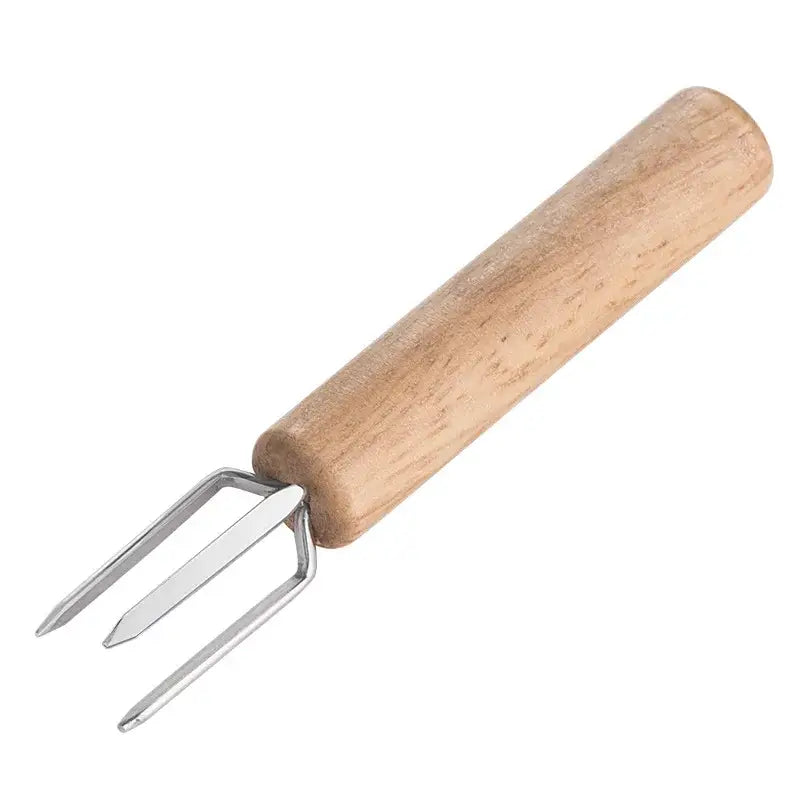 A light brown wooden-handled decorbites espresso stirrer with three slender shiny metal tines for barista use