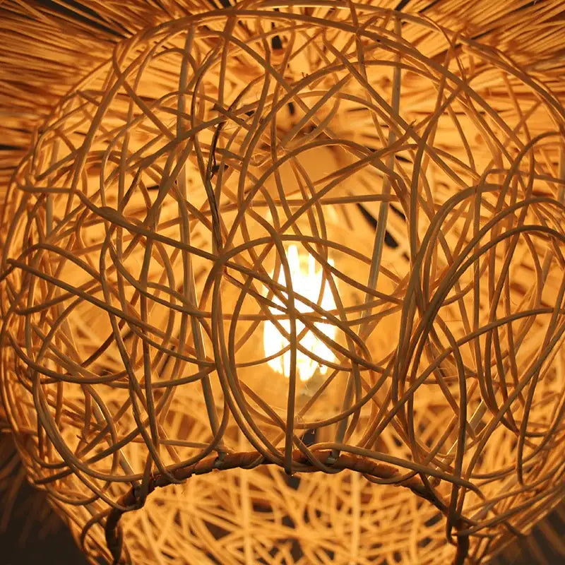 Warm-toned natural woven rattan pendant light with glowing bulb center ideal as rattan pendant lights for dining room