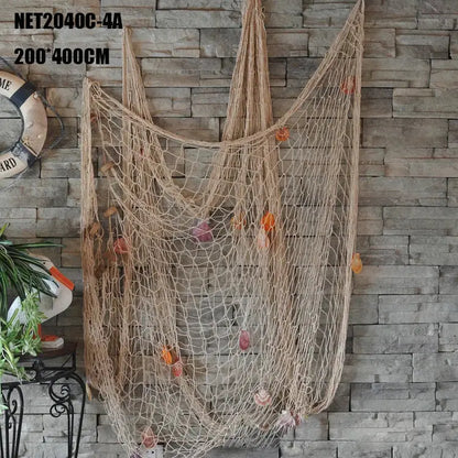 Beige decorative fishing net wall hanging with colorful seashells and dried leaves for nautical bedroom decor