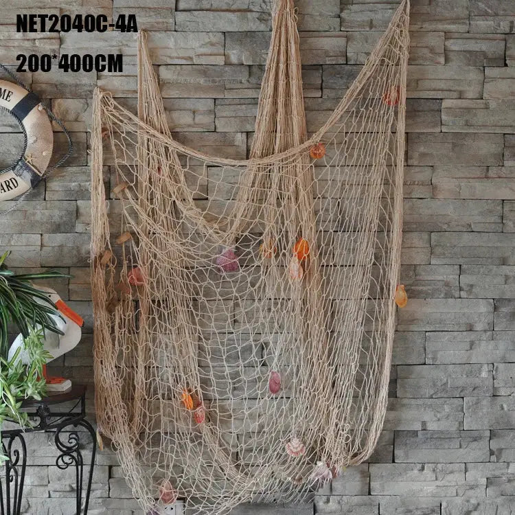 Beige decorative fishing net wall hanging with colorful seashells and dried leaves for nautical bedroom decor