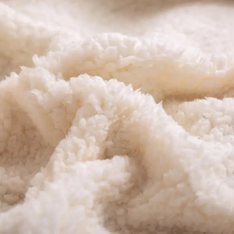 Cream-colored plush faux shearling fabric on the back of decorbites cozy printed flannel blanket for living room use