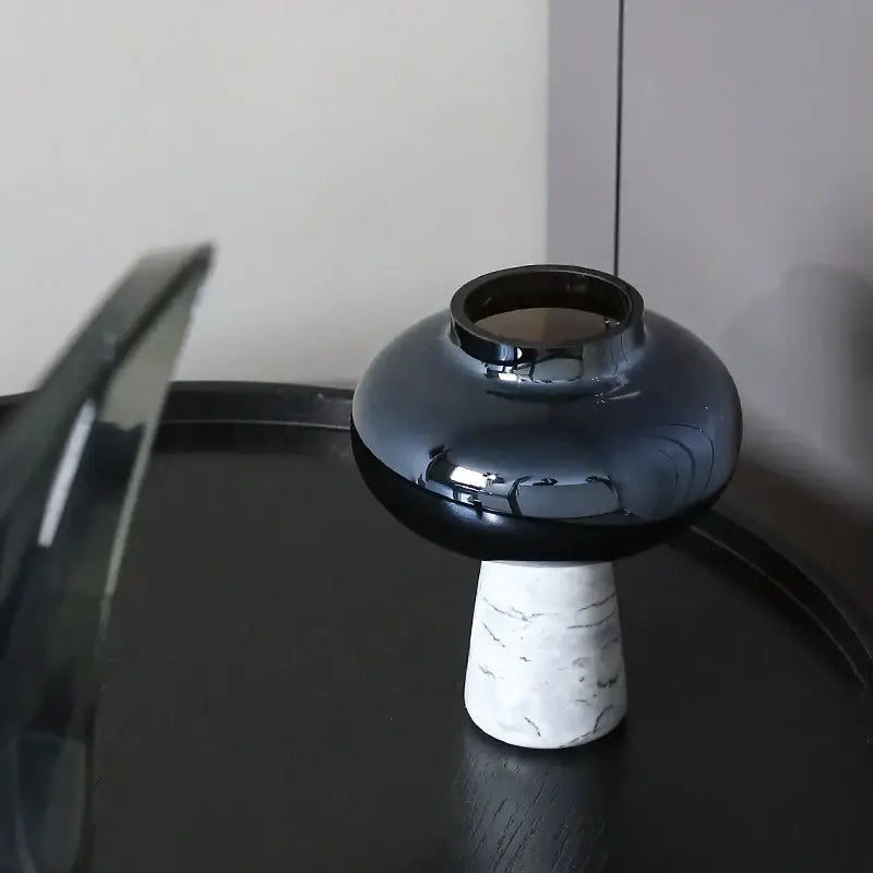 A sleek glossy black ceramic vase with a white marble base and a geometric circle star design for living room decor