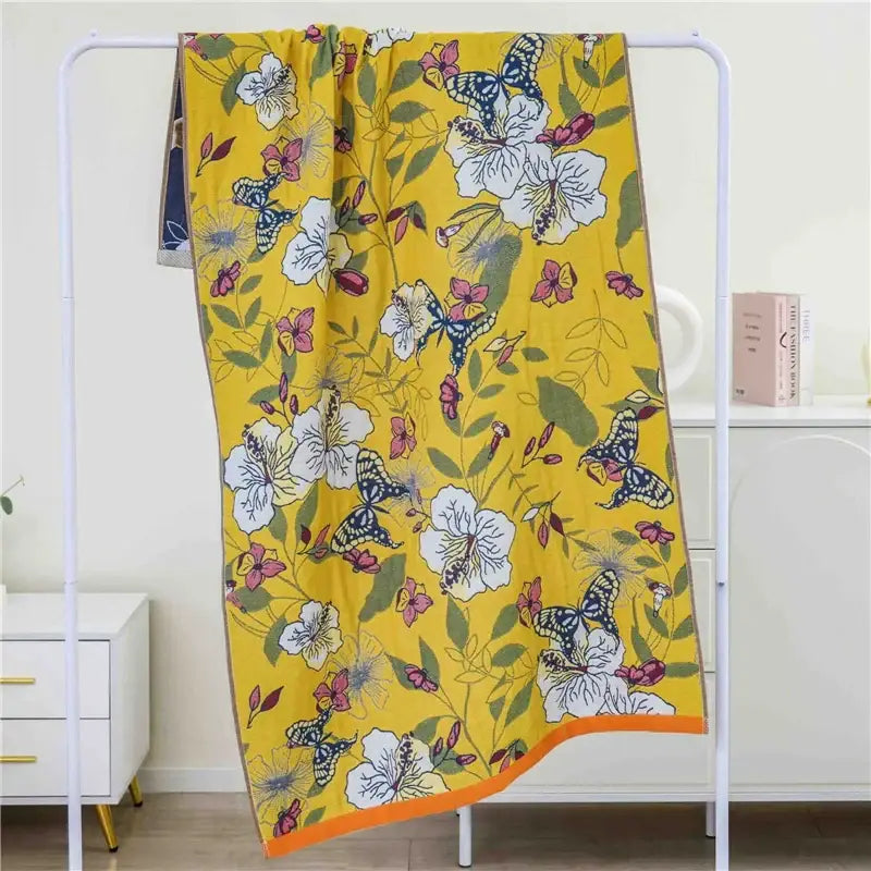 A vibrant yellow cotton gauze bath towel with a butterfly and floral pattern and orange border for decorbites cat bath