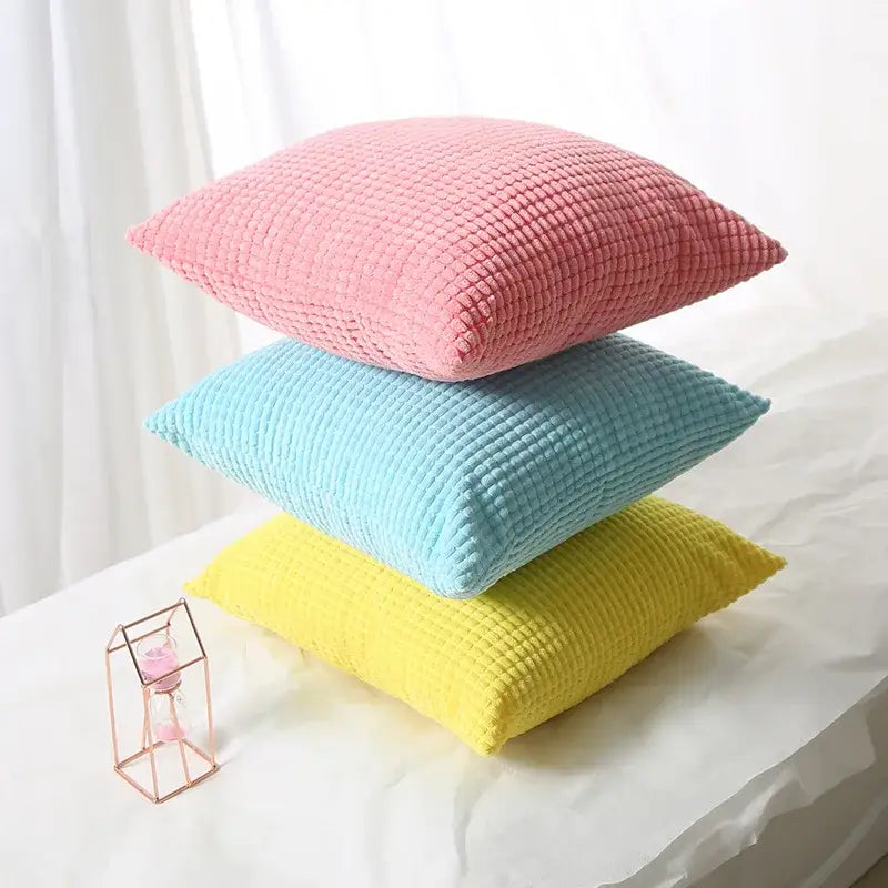 Stacked pastel pink blue and yellow waffle textured throw pillows with navy and charcoal corduroy corn grain cushion cover decorbites corn grain