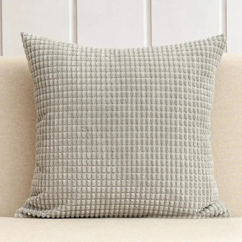 A square light gray waffle-textured throw pillow with plush fabric from the decorbites corduroy corn grain cushion cover set