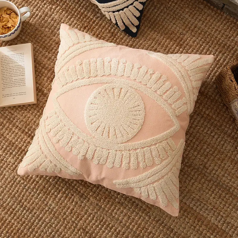A soft pink pillow cover with a prominent cream embroidered cotton eye design for living room decorbites decor