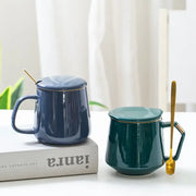 Navy and emerald ceramic mug set with lids and matching gold-trimmed spoons for elegant kitchen drinkware