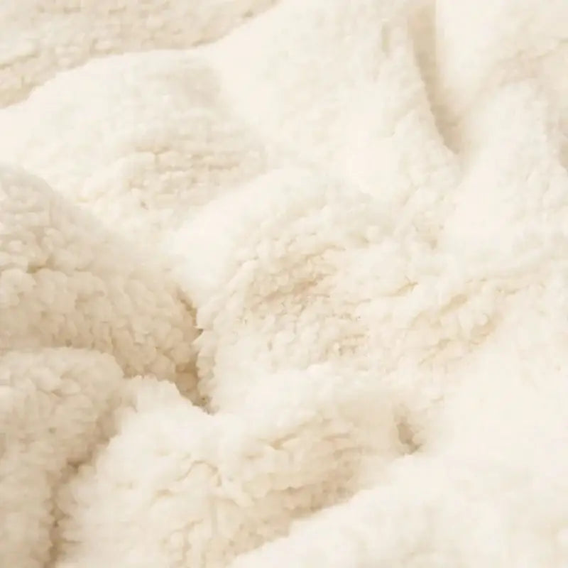Cream-colored plush fleece double layer queen blanket with soft textured surface for sherpa comfort in bedroom