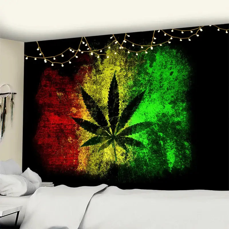 Rasta-themed wall tapestry with a black cannabis leaf silhouette on a red yellow and green background featuring printed maple leaf decor