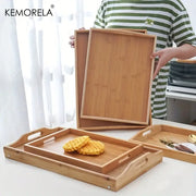 Set of nested light brown rectangular wooden trays made of bamboo with integrated handles for kitchen storage