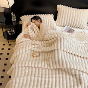 Cream-colored plush chunky knit blanket with ribbed texture made from bamboo fiber for autumn warmth and softness