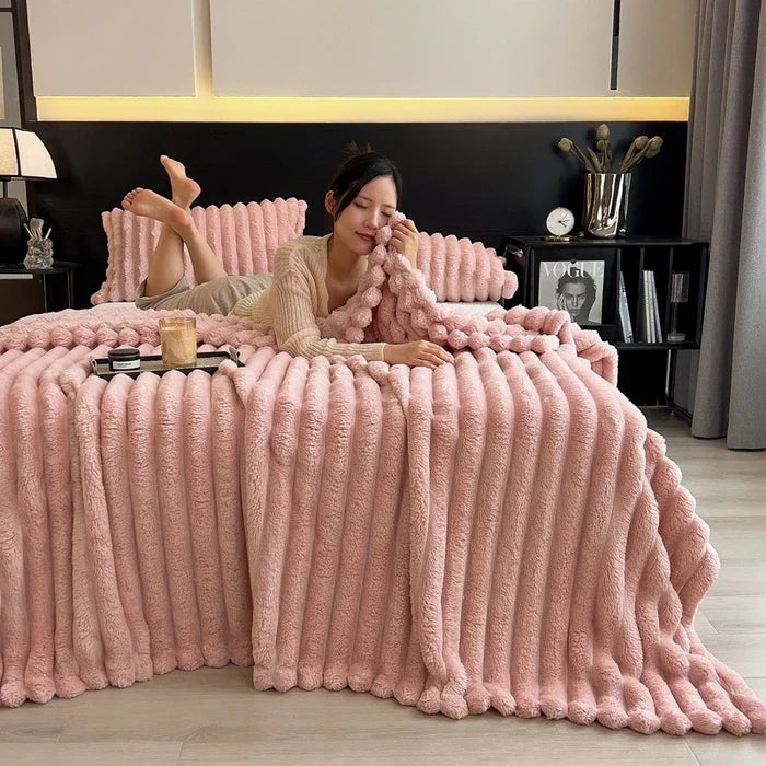 Pink plush ribbed throw blanket with soft fuzzy texture made of coral fleece and bamboo fiber for autumn warmth