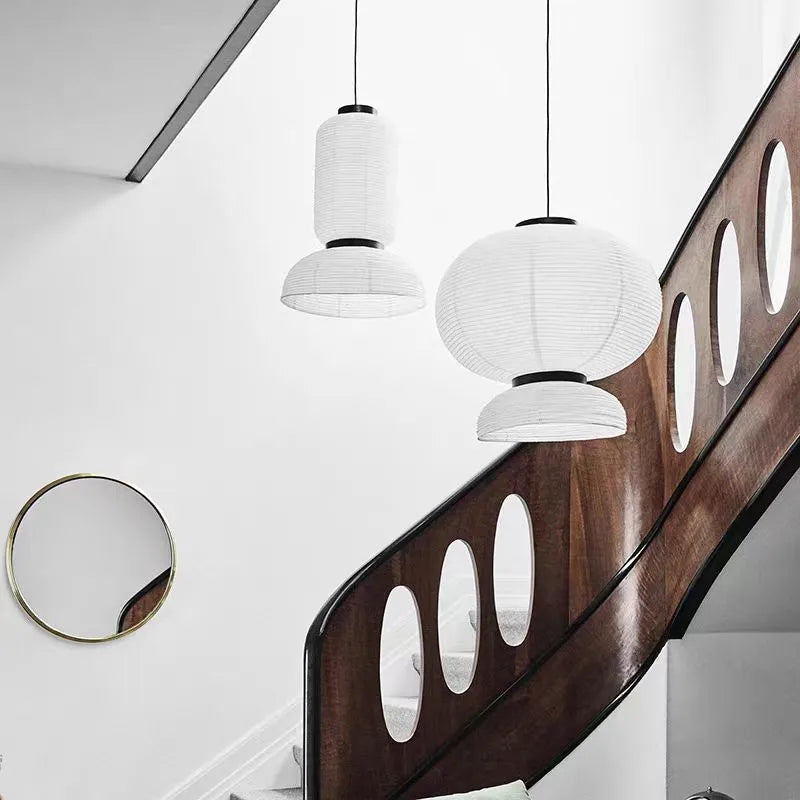 White paper rice paper lantern pendant light with black metal accents hanging above wooden staircase for dining room shop hanging light