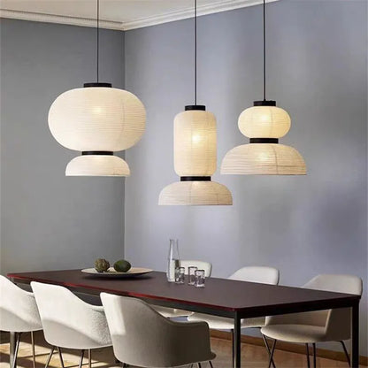 Three elegant off-white rice paper Noguchi lantern lights with black metal hang as dining room shop hanging light