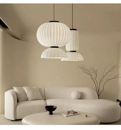 White pleated paper noguchi pendant lights with black metal accents hang above a dining room as shop hanging lantern light