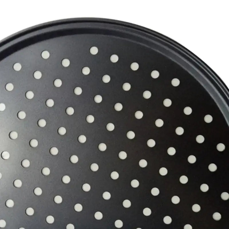 Black non stick carbon steel perforated pizza pan with evenly spaced holes for efficient baking tray use by decorbites