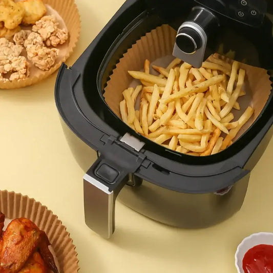 Black and silver air fryer with golden french fries using nonstick parchment paper liners for kitchen air fryer baking