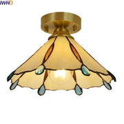 A brass-finished glass copper led ceiling light with amber and teal stained glass petals for bedroom use