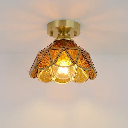 A warm amber-tinted glass copper led ceiling light with brass frame and geometric petal design for bedroom use