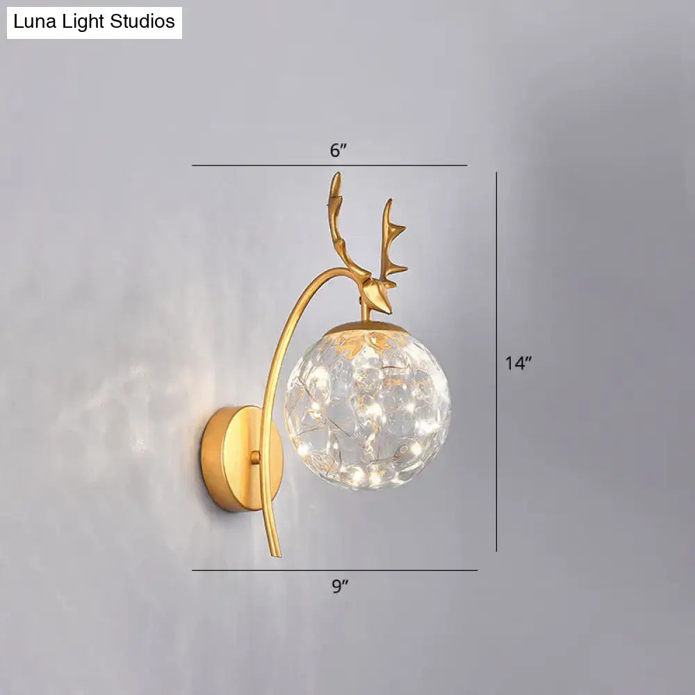 Gold-toned nordic ball wall deer-head sconce with a faceted crystal globe housing warm led lights for bedroom use