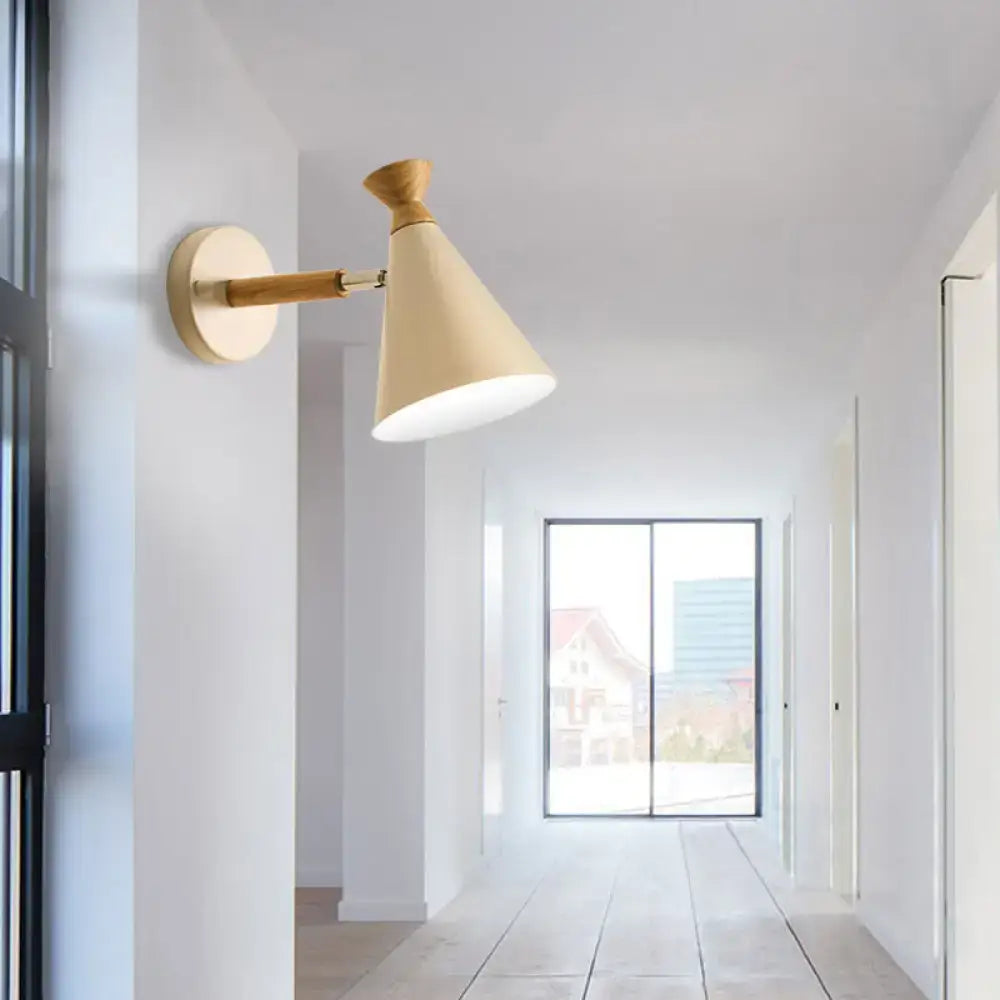 Beige wall light with metal cone shade, wooden arm, brass accents, ideal for bedroom reading lamp