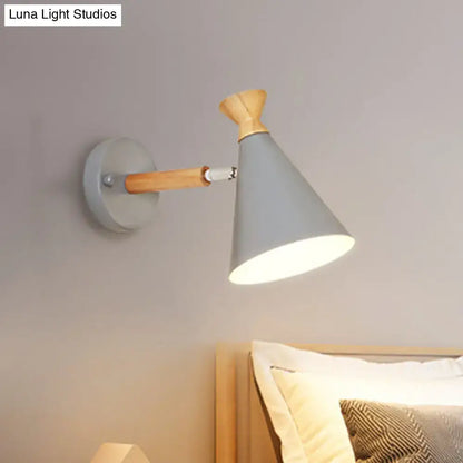 Gray conical wall light with metal cone shade and wooden arm featuring minimalist Nordic blue design for bedroom reading