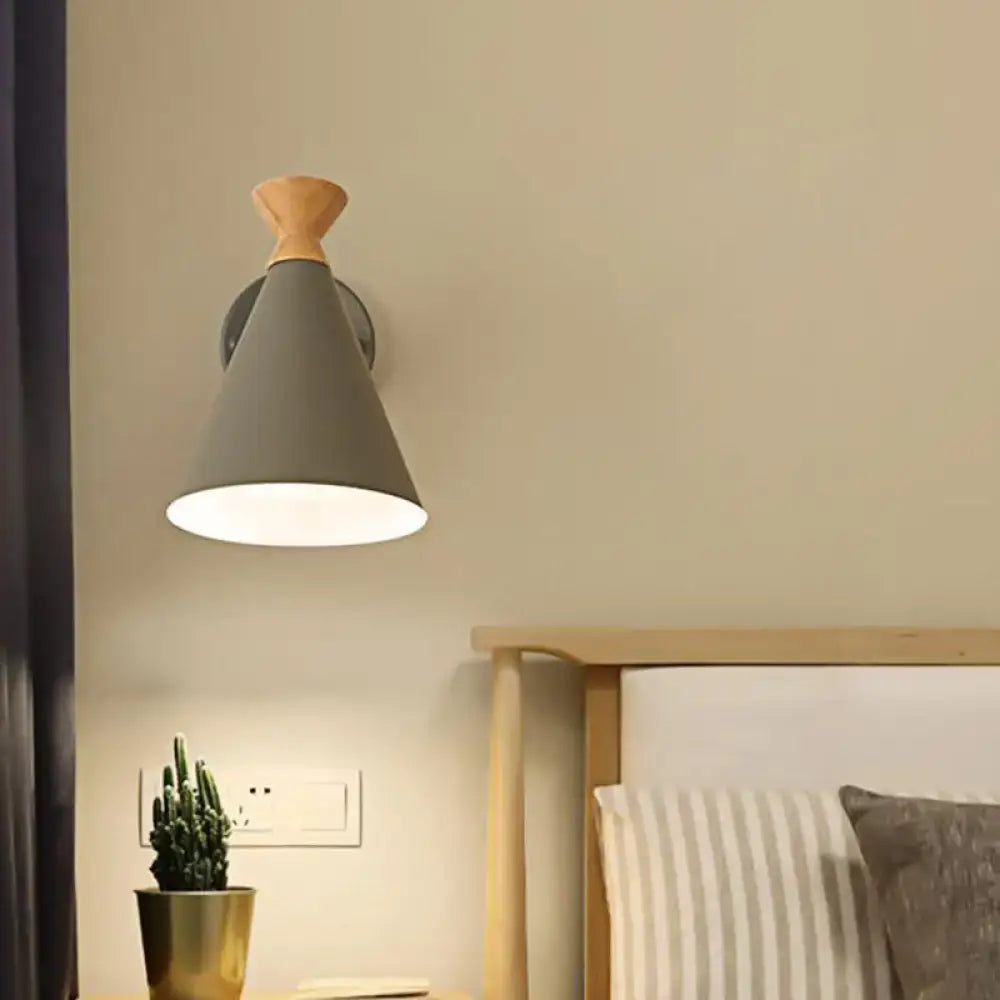 Gray conical wall light with wooden top and metal cone shade designed for bedroom reading use