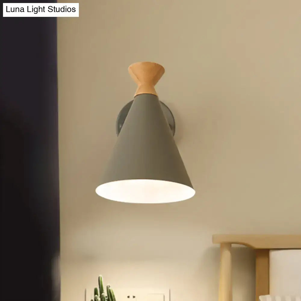 Gray conical wall light with wooden top and metal cone shade mounted on metal bracket for bedroom reading lamp