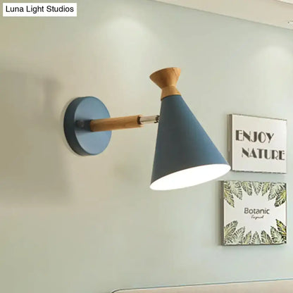 Modern blue wall light featuring a metal cone shade with a wooden arm and base for bedroom reading