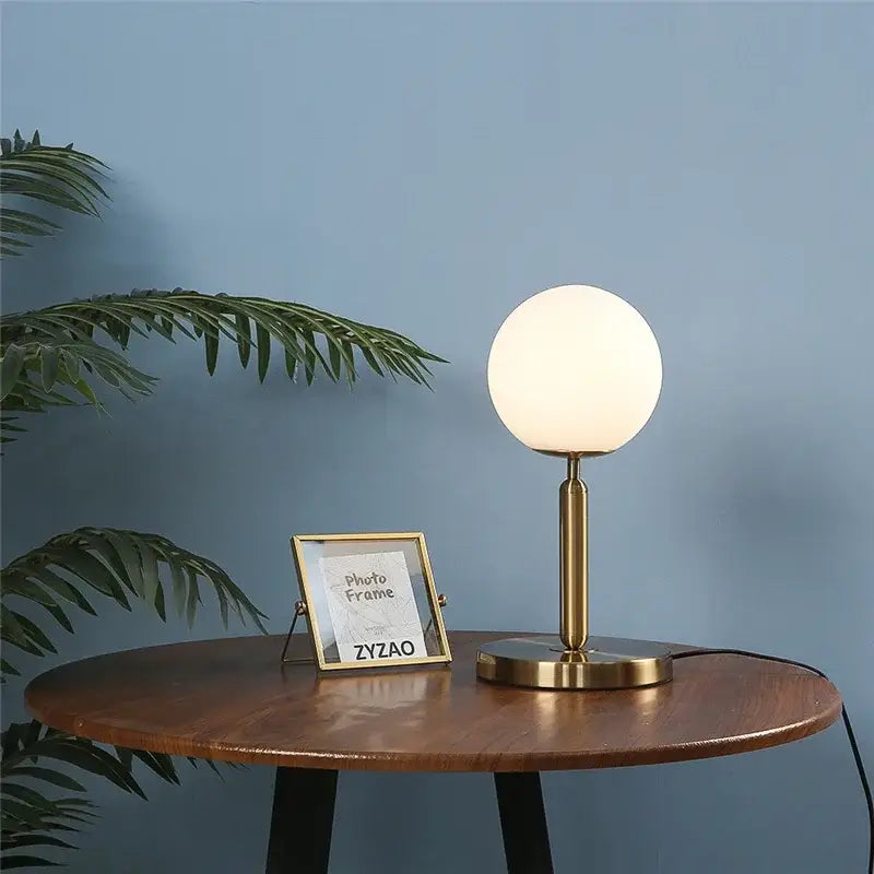 Nordic brass and glass ball led table lamp with gold-toned base and frosted glass globe shade for bedroom decorbites decor