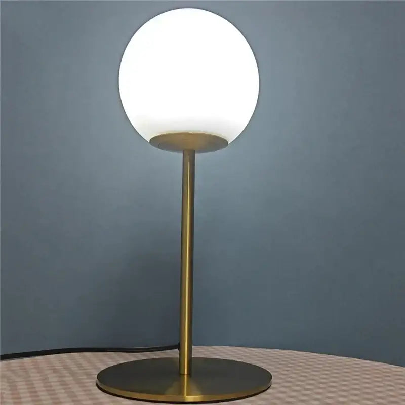 A sleek nordic brass finished table lamp with a frosted white glass ball led shade for bedroom decorbites decor