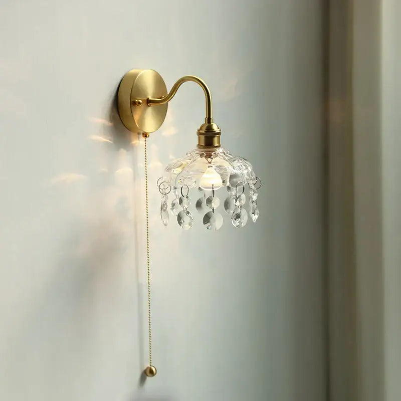 Vintage nordic brass crystal glass led wall light with ornate curved arm and dangling crystal droplets for bedroom decorbites