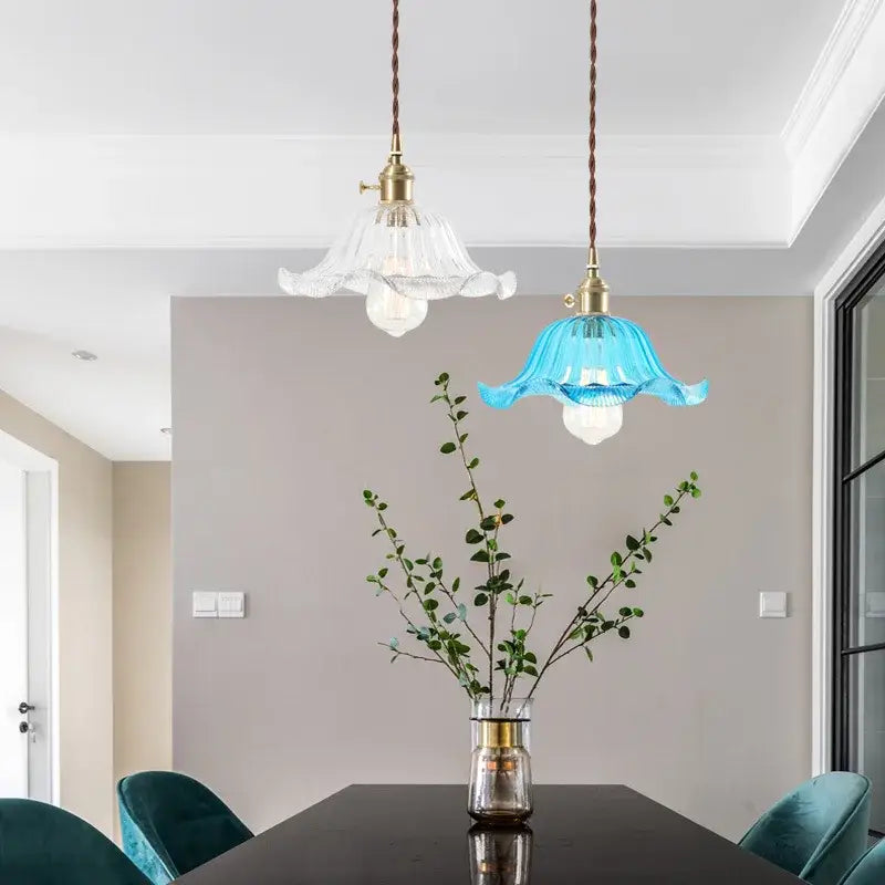 Two nordic brass glass flounce led pendant lights with twisted cords and flower-shaped clear and blue glass shades for dining room