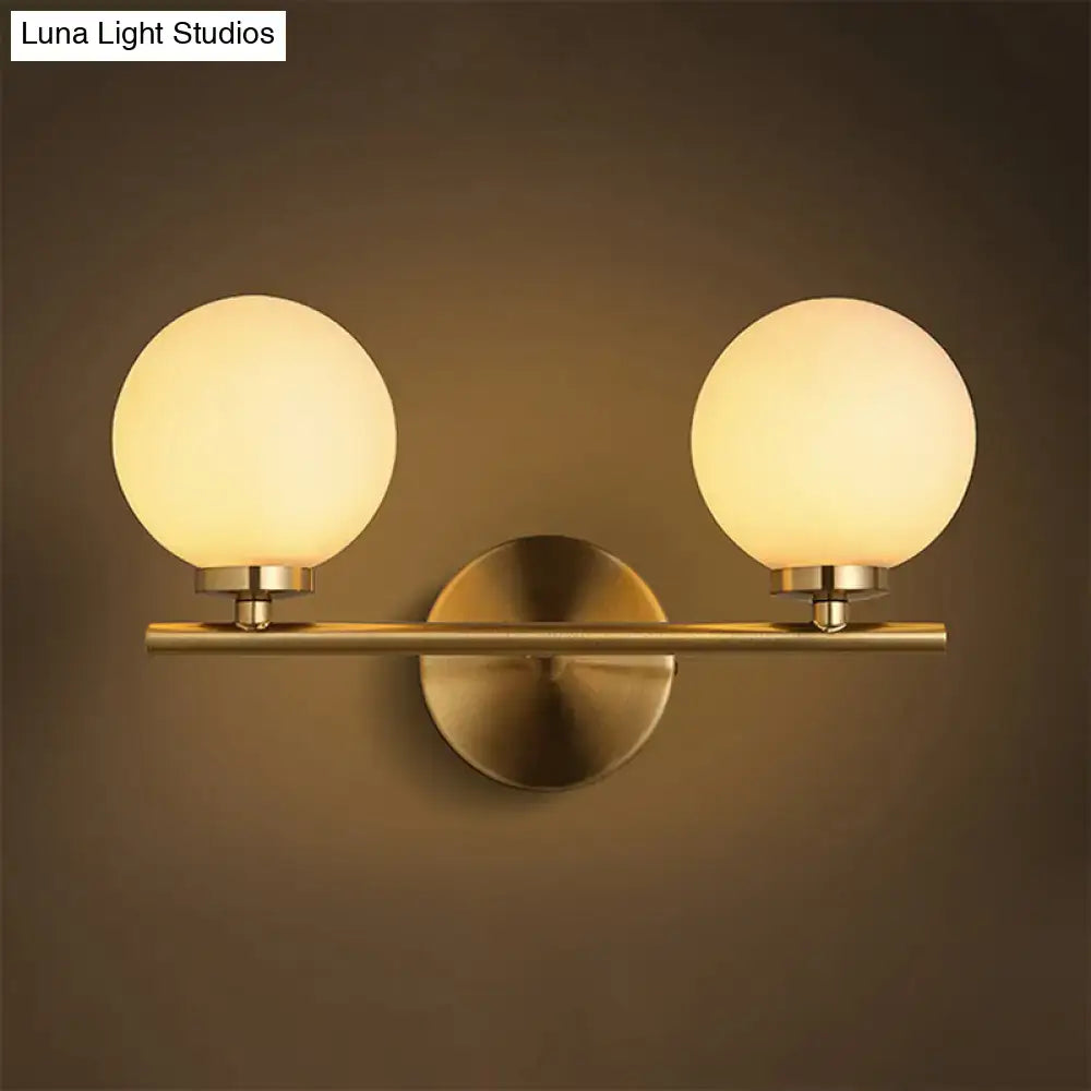 Brass-finished wall sconce light with two frosted glass globe shades for bedroom lighting 110v-120v 220v-240v