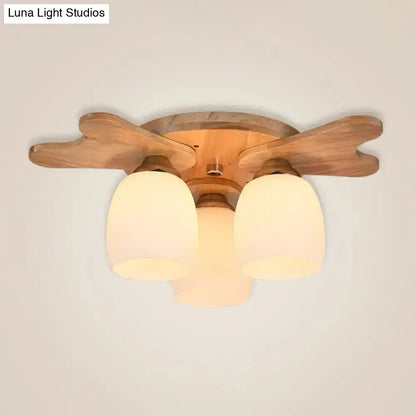Nordic cream glass bell ceiling light featuring three warm-toned cream glass shades and wooden leaf-shaped arms