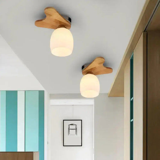 Two warm-toned wooden ceiling lights with cream glass bell frosted shades for bedroom lighting in nordic style