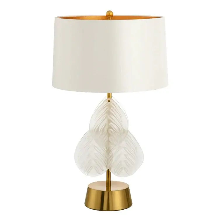 Elegant white leaf-shaped crystal table lamp with gold-toned brass base and trim for bedroom use