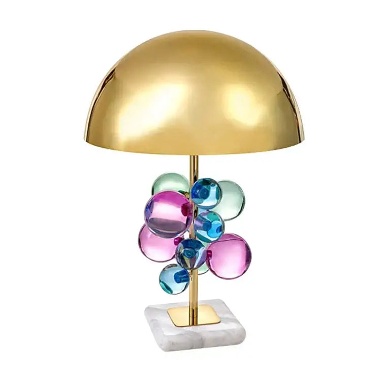 Nordic crystal table lamp with gold dome, colorful glass orbs on brass stem, resting on a white marble base